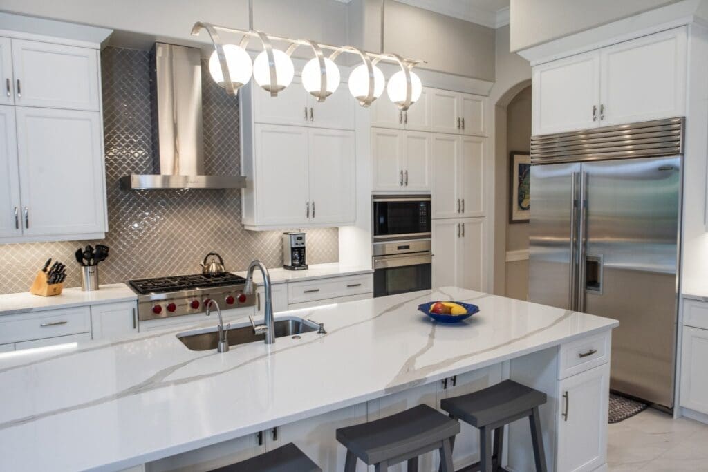Newly remodelled kitchen with white cabinetry, and quartz countertop installed by Cornerstone Builders
